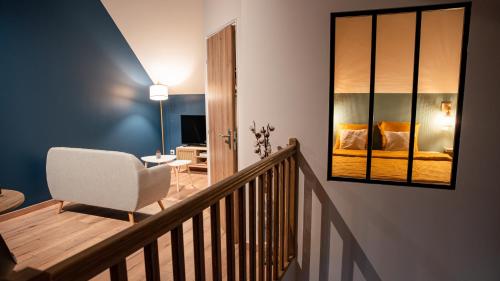 een kamer met een trap met een stoel en een slaapkamer bij Evaziona in Blairville