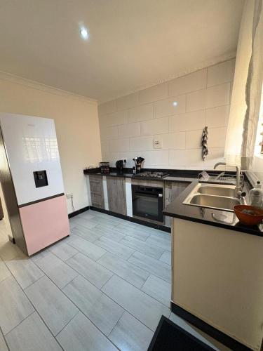 a large kitchen with a refrigerator and a sink at Pumuzika in Livingstone