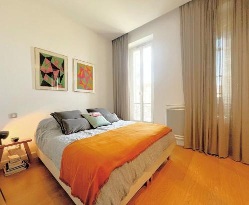une chambre avec un lit avec une couverture orange dans l'établissement Vauban Chic, à Marseille