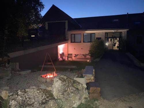a home at night with a fire in the yard at La Ferme des Arêtes in La Chaux-de-Fonds