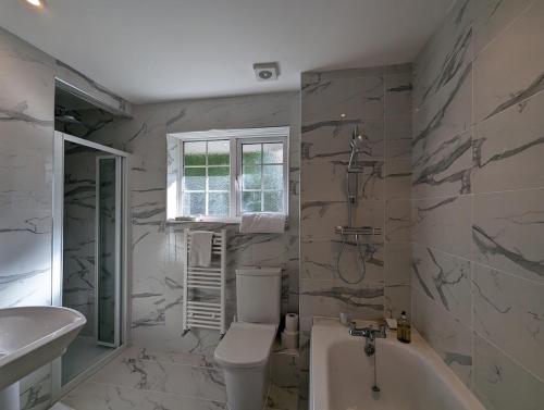 a bathroom with a tub and a toilet and a sink at Spacious 4 Bed Gem near East Croydon Station in South Norwood