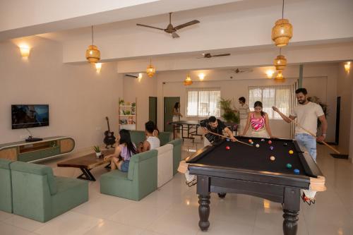 a group of people playing pool in a living room at Voyage Zo Lonavala in Lonavala