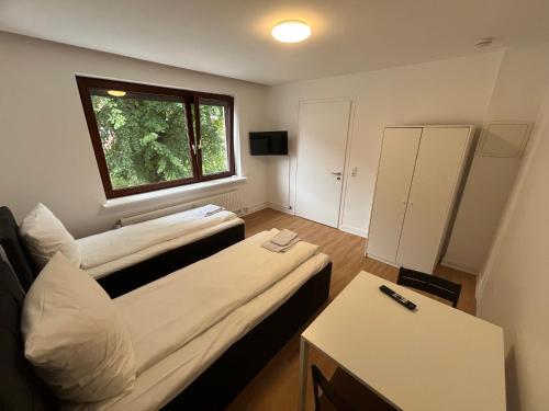a small room with two beds and a window at Monteure und Pendler willkommen! Komfortable 2 Zimmer Apartments in der Innenstadt in Neumünster