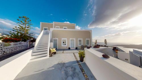 a white house with a staircase on the side of it at NEOKLASSIKO KOUKOULI in Fira