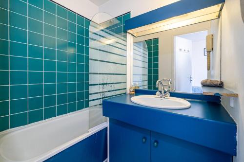 une salle de bain bleue avec un lavabo et un miroir dans l'établissement Studio hypercentre gare, à Nice