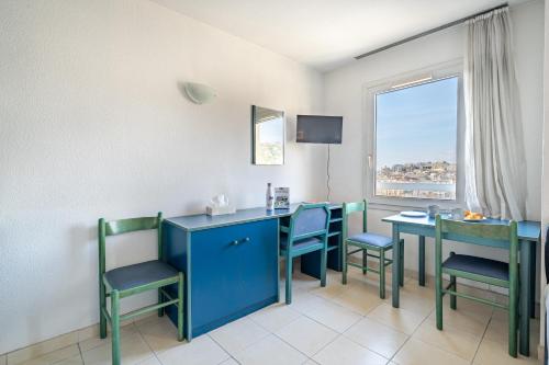 Cette chambre dispose de tables et de chaises bleues ainsi que d'une fenêtre. dans l'établissement Studio hypercentre gare, à Nice