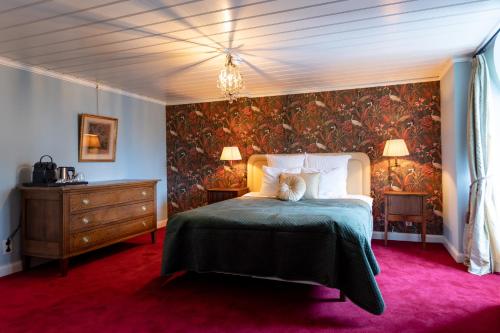 a bedroom with a large bed with a green blanket at Landgoed Loenen B&B in Slijk-Ewijk