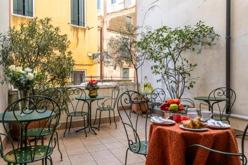 an outdoor patio with a table and chairs with fruit at Hotel Casa Verardo Residenza d'Epoca in Venice