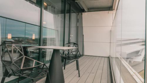 a balcony with a table and chairs in a building at Hilton Aberdeen TECA in Aberdeen