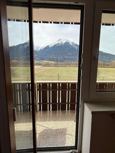 a view of a snow covered mountain through a door at Pension Plattenhof in Telfs