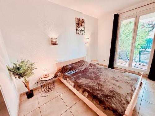 sypialnia z łóżkiem w pokoju z oknem w obiekcie Appartement calme avec jardin privatif - 3 - w mieście Canet-en-Roussillon