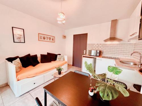 un salon avec un canapé et une table dans l'établissement Appartement calme avec jardin privatif - 3 -, à Canet