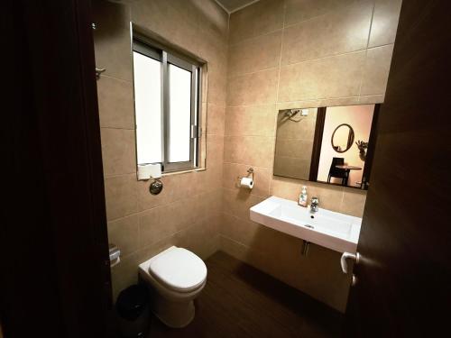 a bathroom with a toilet and a sink and a window at Slimiza Suites in Sliema