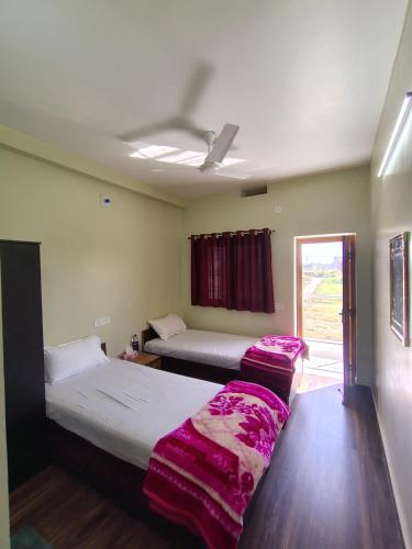 a room with two beds and a window at Marina Home Stay in Bodh Gaya
