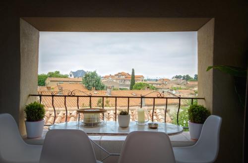 une table et des chaises sur un balcon avec vue dans l'établissement Les clés de la Cité - 5 appartements, à Carcassonne