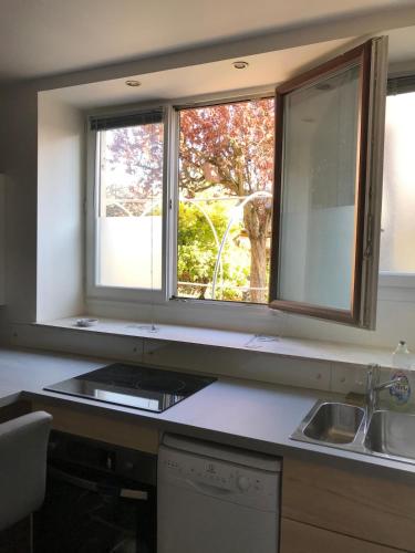 a kitchen with two windows and a sink at Studio entièrement équipé au coeur du centre ville in Anse