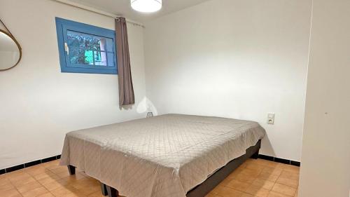 un petit lit dans une chambre avec une fenêtre dans l'établissement Semaphore 24, à Sainte-Maxime