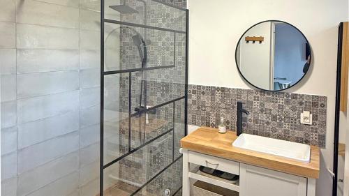 une salle de bain avec une douche avec un lavabo et un miroir dans l'établissement Semaphore 24, à Sainte-Maxime
