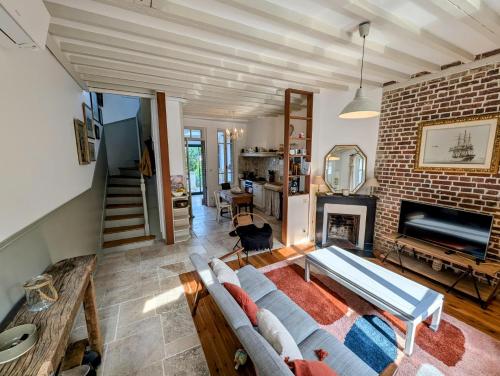 un salon avec un canapé et un mur de briques dans l'établissement Maison vue mer avec jardin - Villa Trabendo, au Tréport