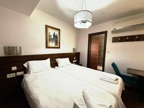 a bedroom with a large bed with white sheets at Slimiza Suites in Sliema