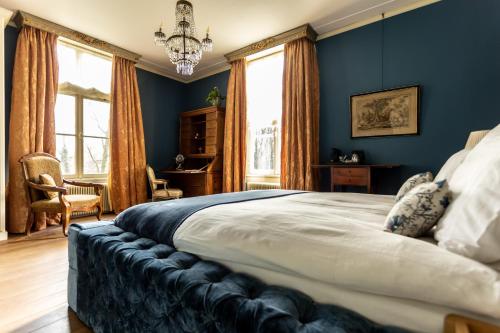 a bedroom with a large bed with blue walls at Landgoed Loenen B&B in Slijk-Ewijk