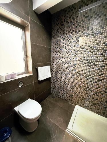 a bathroom with a toilet and a shower and a window at Slimiza Suites in Sliema