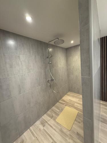 y baño con ducha y alfombra amarilla. en Villa Le domaine des Reves, en Hauteville-Lompnes