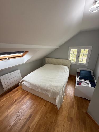 1 dormitorio con 1 cama blanca en el ático en Villa Le domaine des Reves, en Hauteville-Lompnes