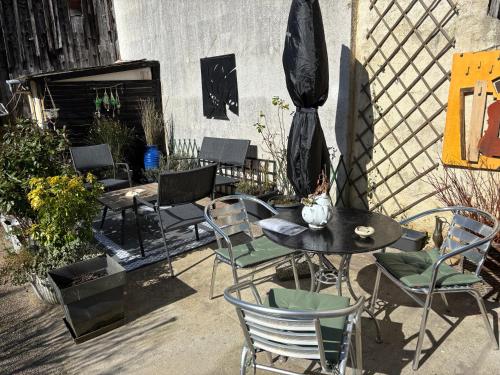 a patio with tables and chairs and a fence at Dom’s Garden in Livarot