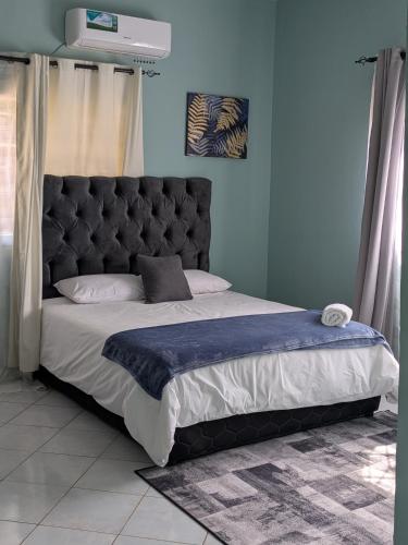 a bed with a black headboard in a bedroom at Kwandu Apartments in Livingstone