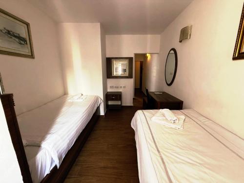 a room with two beds and a mirror at Slimiza Suites in Sliema