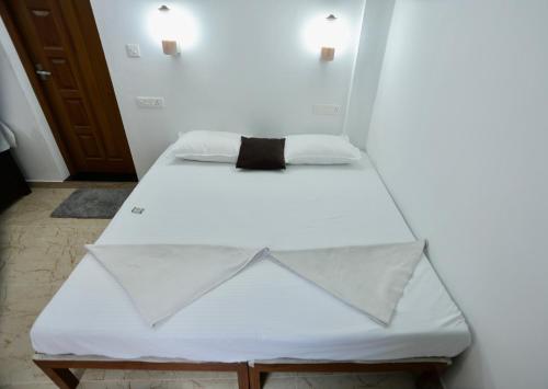 a white bed with a bow tie on it at Marari John Villa in Mararikulam