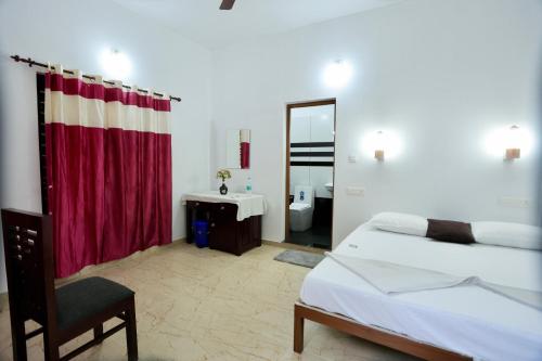 a bedroom with a bed and a sink and a mirror at Marari John Villa in Mararikulam