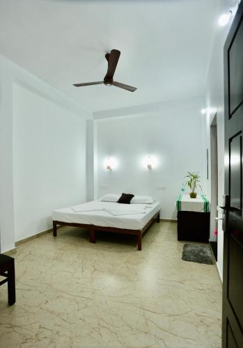 a white room with a bed and a ceiling at Marari John Villa in Mararikulam