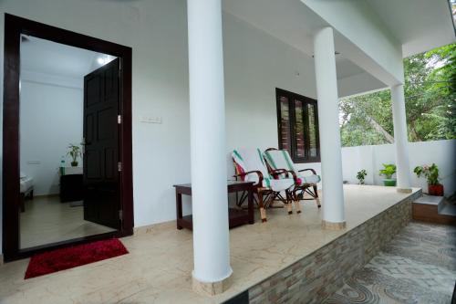a room with a mirror and a table and chairs at Marari John Villa in Mararikulam