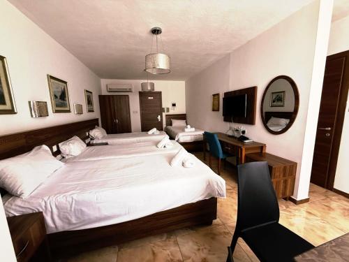 a bedroom with a large white bed and a desk at Slimiza Suites in Sliema