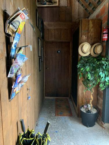 a hallway of a cabin with a door and hats at Dom’s Garden in Livarot