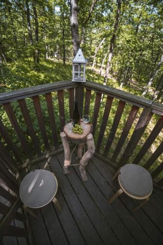 a table and two chairs on a deck with a bird feeder at TREE HOUSE U Mravence in Jinačovice