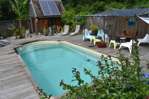 - une piscine sur une terrasse en bois avec des chaises et une table dans l'établissement Le Refuge de Valprofonde, à Villeneuve-sur-Yonne