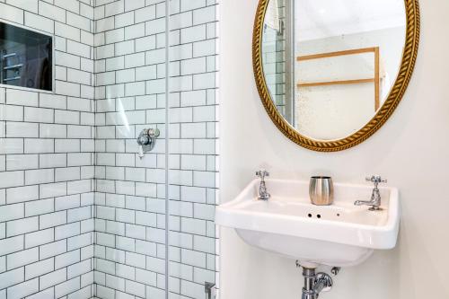 a bathroom with a sink and a mirror at Constantia Klein in Cape Town