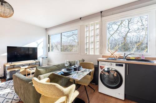 - un salon avec une table et un lave-linge dans l'établissement Mobility lease - Studio 10 minutes from Paris, à Boulogne-Billancourt