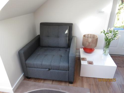 a chair in a living room next to a table at The Loft at Log Ness in Inverness