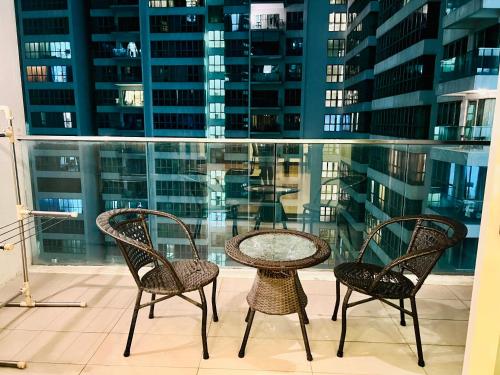 a table and chairs on a balcony with buildings at Regalia Spritz Empire Hostel in Kuala Lumpur