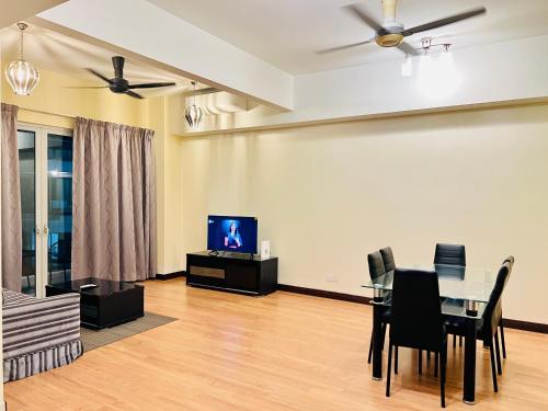 a living room with a dining table and a tv at Regalia Spritz Empire Hostel in Kuala Lumpur