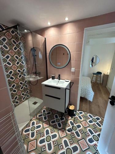 une salle de bain avec un lavabo et un miroir dans l'établissement Appartement dans le village de Valbonne, à Valbonne