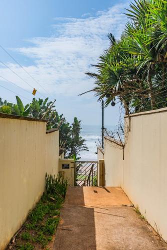 a walkway leading up to a fence with the ocean at Unit 62 Sealodge Umhlanga Beach in Durban
