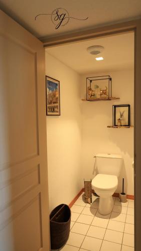 une salle de bain avec des toilettes blanches dans une chambre dans l'établissement Le terrier du Green appartement, à Levernois