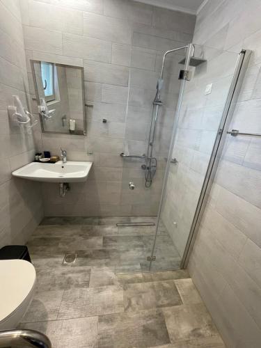 a bathroom with a shower and a sink at Terra Di Pietra Exclusive Suites & Apartments in Areopolis