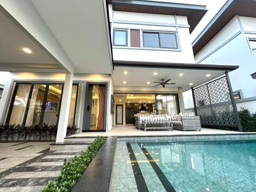 a house with a swimming pool in front of a house at Zensiri Luxury 3BDR Pool Villa in Pattaya