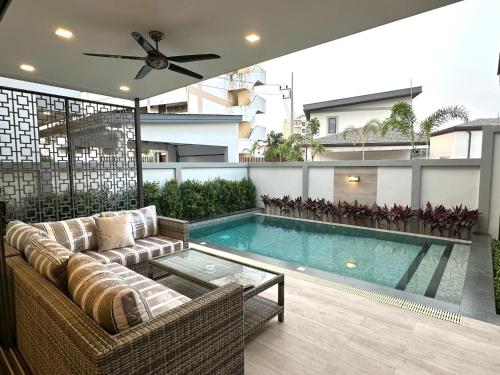 a living room with a couch and a swimming pool at Zensiri Luxury 3BDR Pool Villa in Pattaya